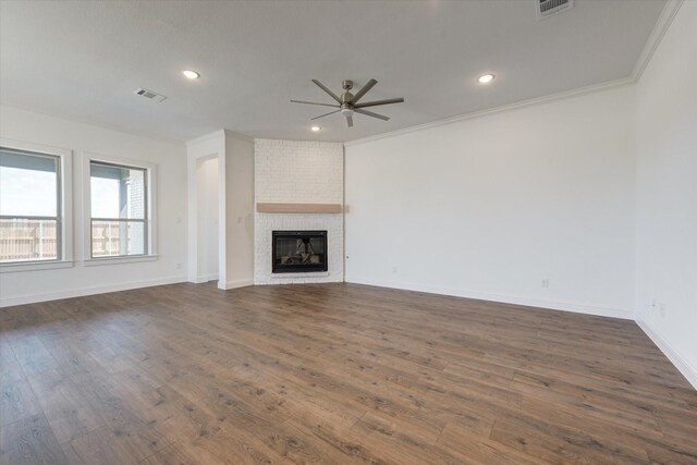 unfurnished living room featuring ceiling fan, a fireplace, dark wood-style floors, and visible vents