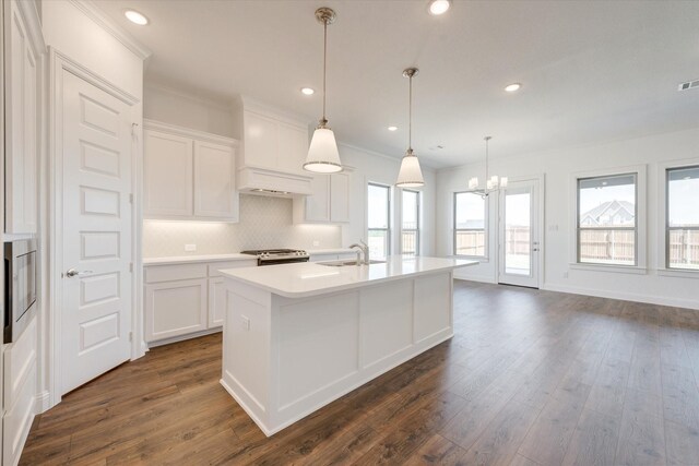 kitchen featuring decorative backsplash, light countertops, a sink, an inviting chandelier, and dark wood-type flooring