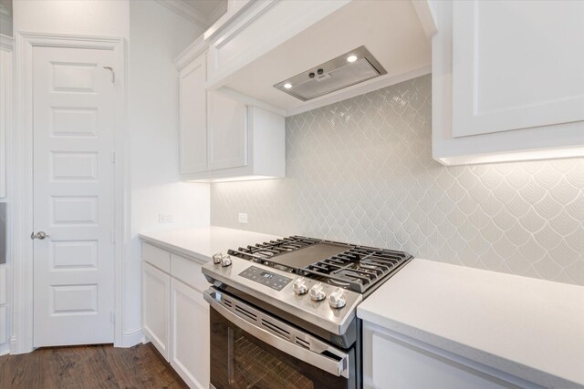 kitchen featuring stainless steel range with gas stovetop, backsplash, white cabinets, and light countertops