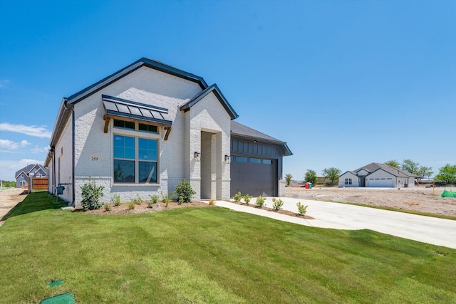view of front of property with a garage, concrete driveway, a front lawn, and brick siding