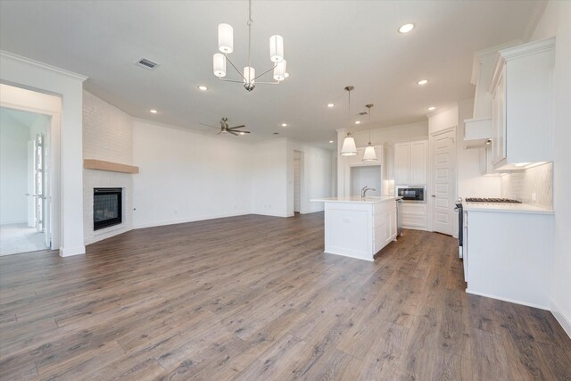 kitchen featuring visible vents, open floor plan, ceiling fan with notable chandelier, and black microwave