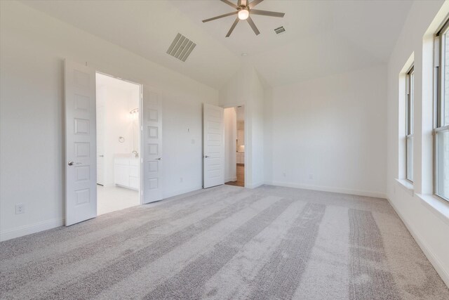 unfurnished bedroom with light colored carpet, lofted ceiling, and visible vents