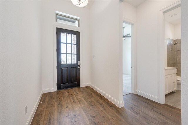foyer with baseboards, ceiling fan, and dark wood finished floors