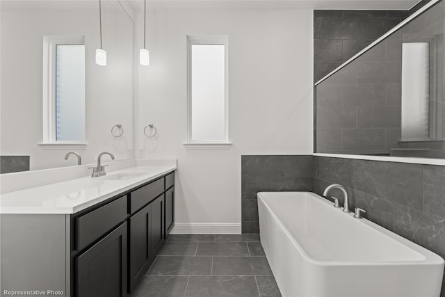 full bath featuring baseboards, a freestanding bath, tile patterned flooring, and vanity