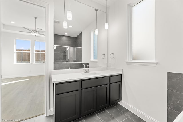 full bath with visible vents, vanity, baseboards, a ceiling fan, and a stall shower