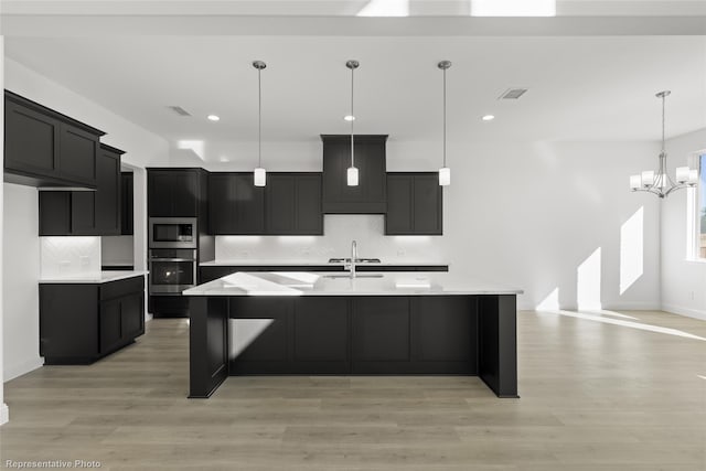 kitchen featuring light countertops, appliances with stainless steel finishes, decorative backsplash, and visible vents