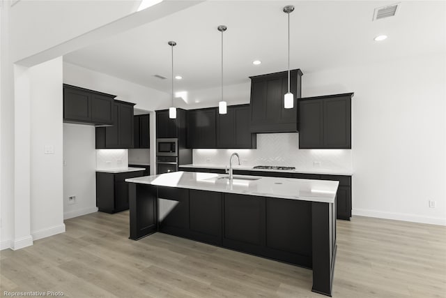kitchen with appliances with stainless steel finishes, a sink, baseboards, decorative backsplash, and visible vents