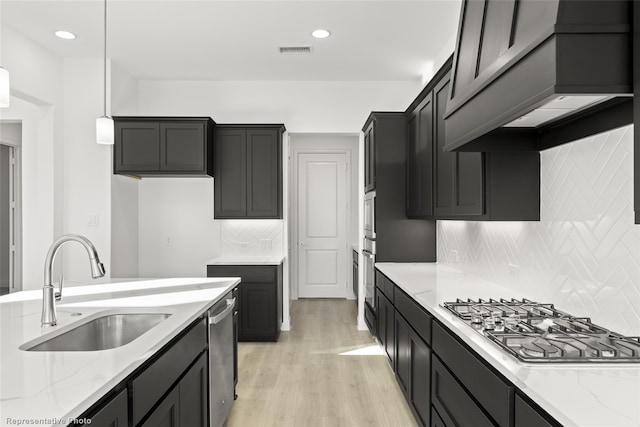 kitchen featuring visible vents, light wood-style flooring, appliances with stainless steel finishes, and light stone countertops
