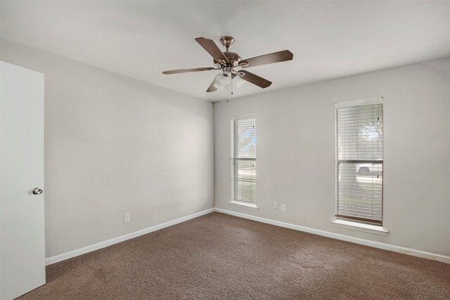 spare room with carpet floors, a ceiling fan, and baseboards