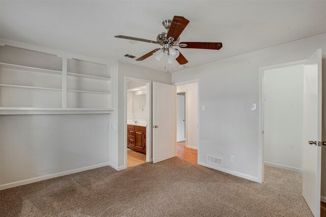 unfurnished bedroom with carpet floors, baseboards, visible vents, and ensuite bath