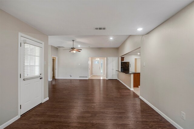 interior space with baseboards, ceiling fan, wood finished floors, and visible vents