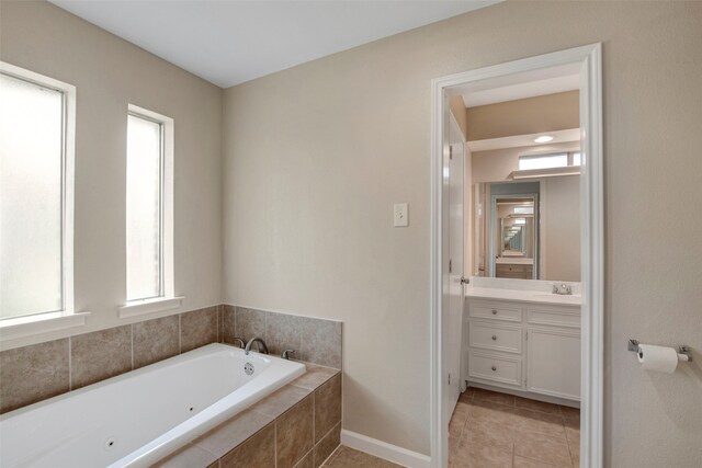 bathroom featuring vanity, tile patterned flooring, a whirlpool tub, and baseboards