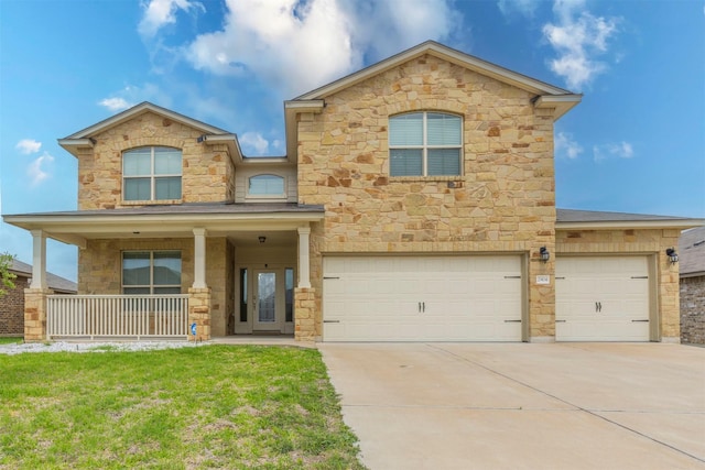 view of front of house with a garage, a porch, driveway, and stone siding