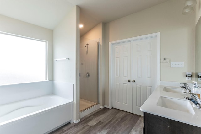 bathroom with a garden tub, a sink, wood finished floors, and a stall shower
