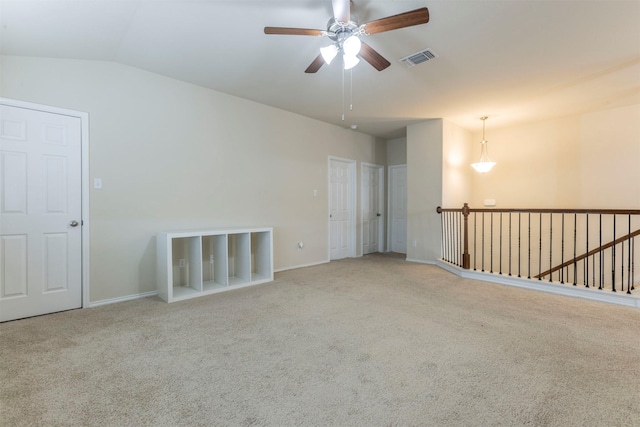 unfurnished room featuring carpet flooring, ceiling fan, baseboards, vaulted ceiling, and visible vents