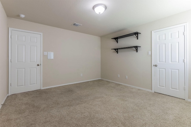 carpeted spare room with baseboards and visible vents