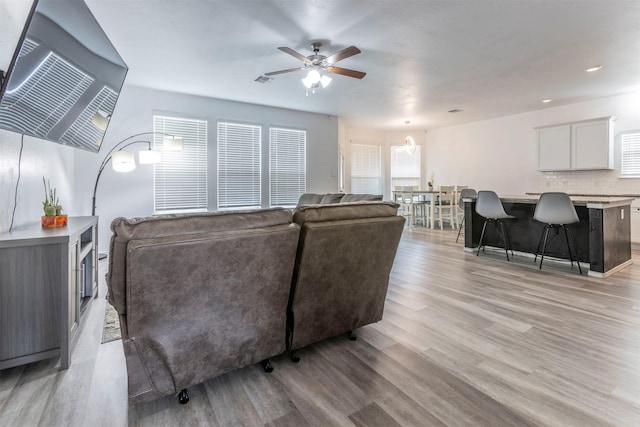 living room with a ceiling fan and light wood finished floors