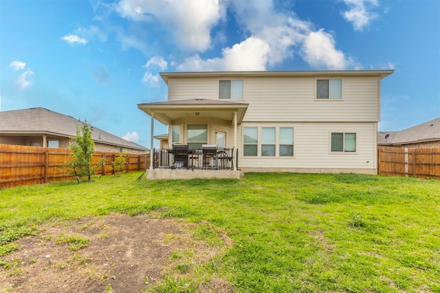 back of house with a lawn, a fenced backyard, and a patio area