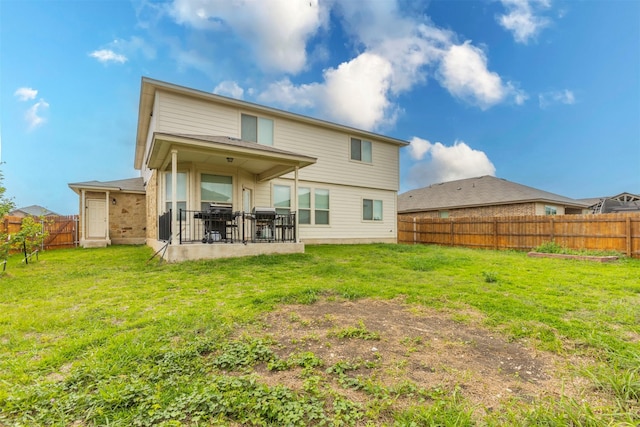 rear view of property featuring a fenced backyard, a yard, and a patio area