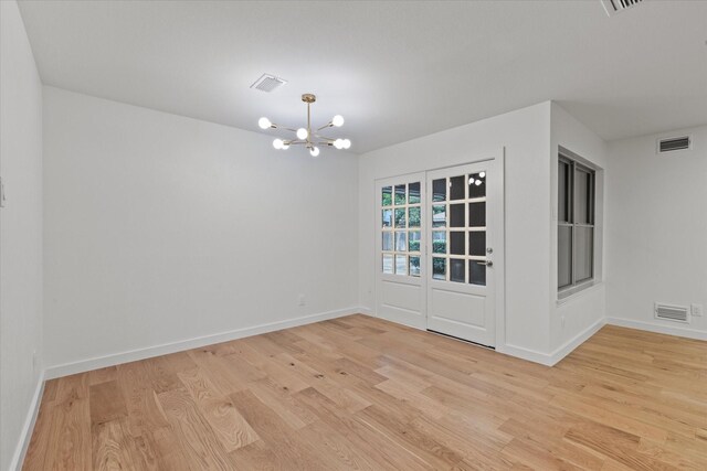 unfurnished dining area with light wood finished floors, a chandelier, and baseboards