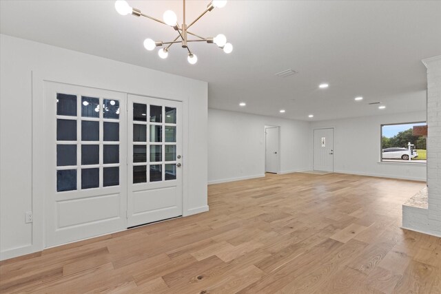 unfurnished living room featuring a chandelier, light wood-style flooring, recessed lighting, and baseboards