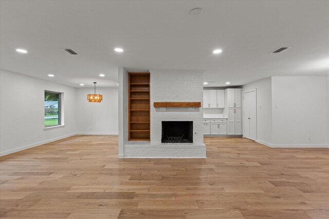 unfurnished living room with baseboards, recessed lighting, light wood-style flooring, and a fireplace