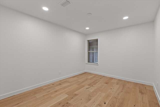 spare room with baseboards, recessed lighting, and light wood finished floors