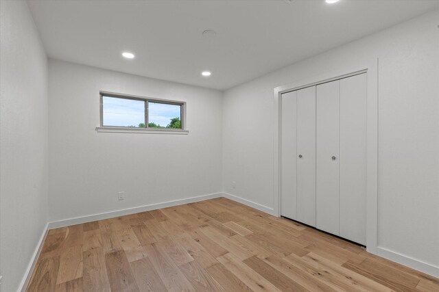 unfurnished bedroom featuring light wood-style floors, recessed lighting, baseboards, and a closet