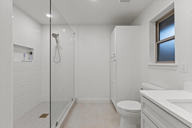 bathroom with walk in shower, toilet, vanity, and baseboards