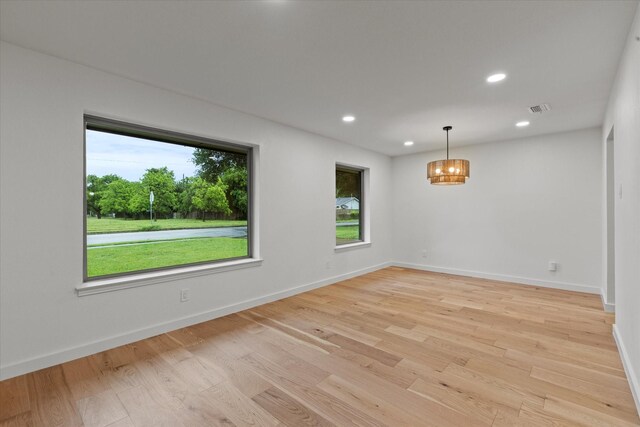 unfurnished room with a chandelier, light wood-style floors, baseboards, and recessed lighting