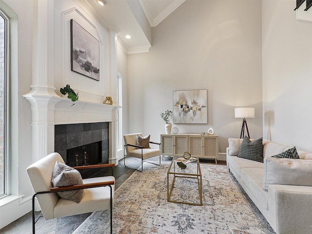 living room with crown molding, recessed lighting, baseboards, and a tiled fireplace