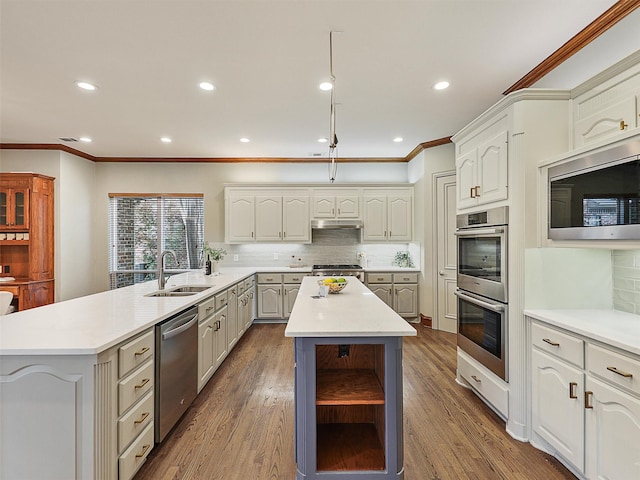kitchen with a sink, appliances with stainless steel finishes, decorative backsplash, and a peninsula