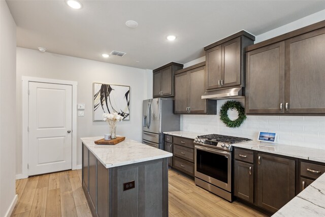 kitchen featuring dark brown cabinets, appliances with stainless steel finishes, visible vents, and light wood-style floors