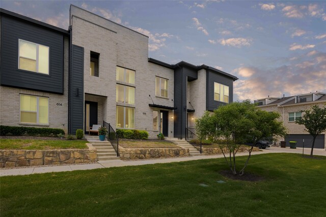 contemporary house featuring brick siding and a front yard
