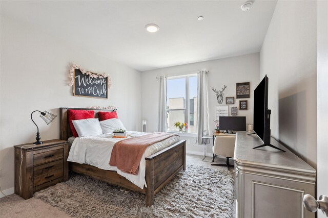 bedroom featuring baseboards and light colored carpet