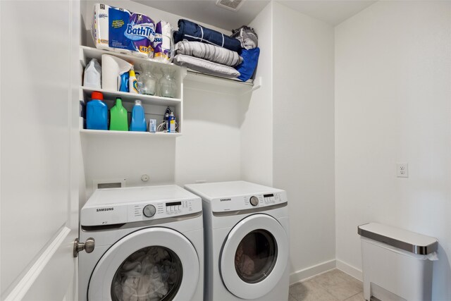 laundry area with washing machine and clothes dryer, laundry area, tile patterned flooring, baseboards, and visible vents