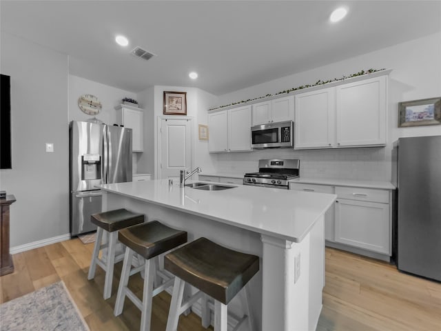 1151 Rumble Ln, Fate, TX 75087 - kitchen featuring visible vents, a sink, light countertops, stainless steel appliances, and light wood-style flooring