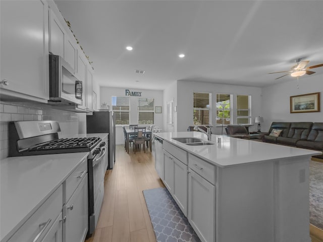 1151 Rumble Ln, Fate, TX 75087 - kitchen featuring a center island with sink, light wood-type flooring, light countertops, a sink, and appliances with stainless steel finishes