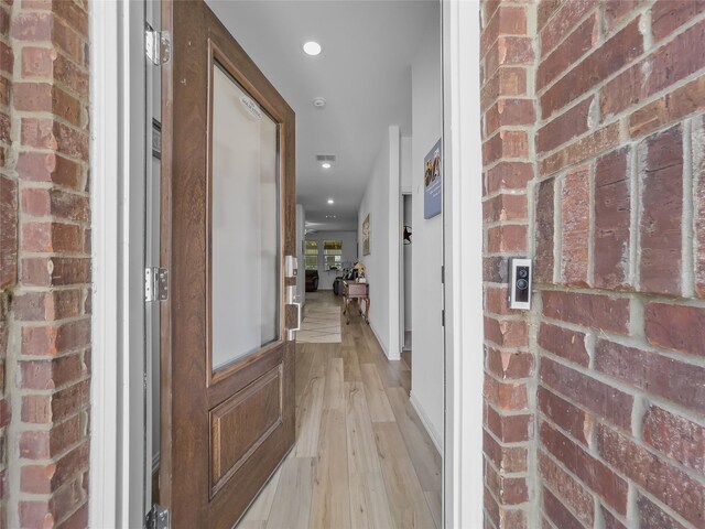 1151 Rumble Ln, Fate, TX 75087 - hallway featuring recessed lighting, brick wall, and light wood finished floors