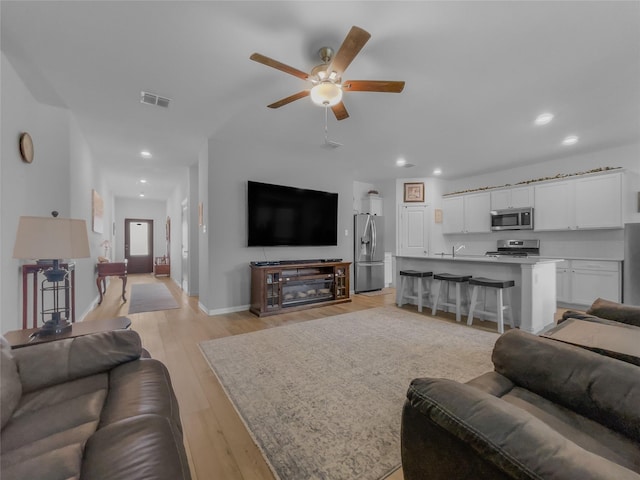 1151 Rumble Ln, Fate, TX 75087 - living room featuring ceiling fan, recessed lighting, baseboards, light wood-type flooring, and visible vents