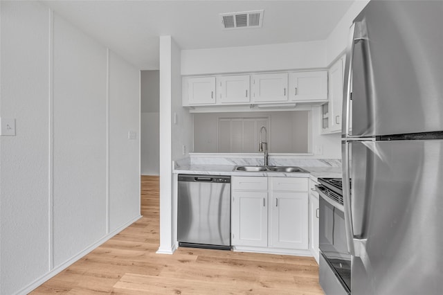 6026 Stoneybrook Dr, Fort Worth, TX 76112 - kitchen featuring white cabinets, appliances with stainless steel finishes, a sink, light wood-style flooring, and visible vents