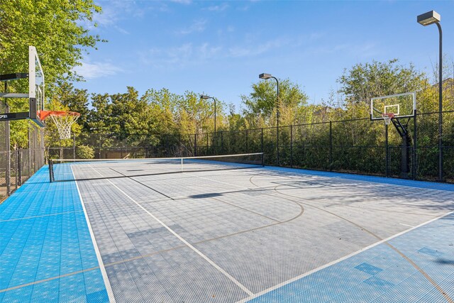 view of sport court with a tennis court, fence, and community basketball court
