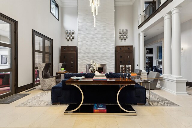 interior space with tile patterned flooring, decorative columns, a towering ceiling, and baseboards