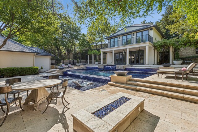 outdoor pool featuring a patio, a hot tub, an outdoor fire pit, and outdoor dining space