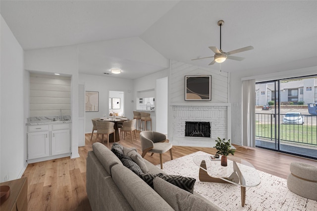 6034 Stoneybrook Dr, Fort Worth, TX 76112 - living area featuring light wood-style floors, a ceiling fan, vaulted ceiling, and a fireplace