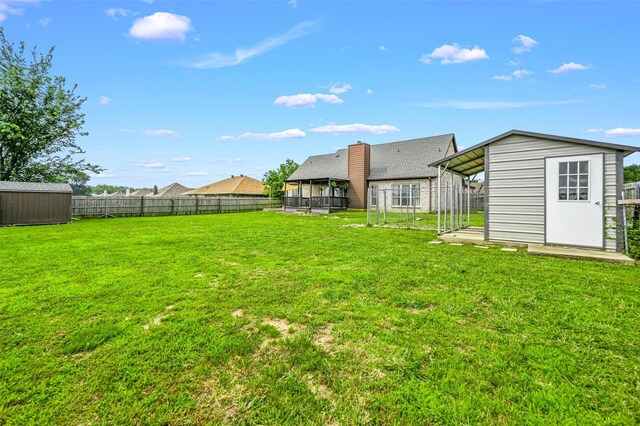 view of yard with a fenced backyard, an outbuilding, and a shed