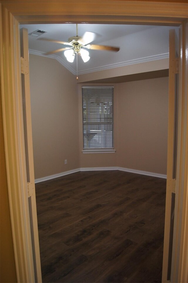 unfurnished room with ceiling fan, dark wood finished floors, baseboards, visible vents, and ornamental molding