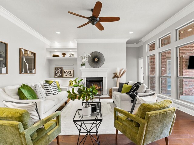 living room featuring crown molding, ceiling fan, a glass covered fireplace, recessed lighting, and wood finished floors