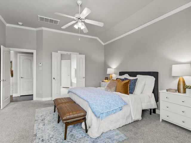 carpeted bedroom with visible vents, ornamental molding, lofted ceiling, baseboards, and connected bathroom