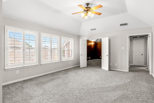 unfurnished bedroom with carpet floors, lofted ceiling, visible vents, and multiple windows